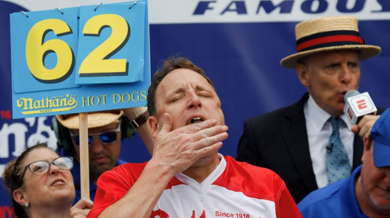 Džoijs Čestnats notiesā uzvaras - 62. - hotdogu. Foto: EPA/Scanpix