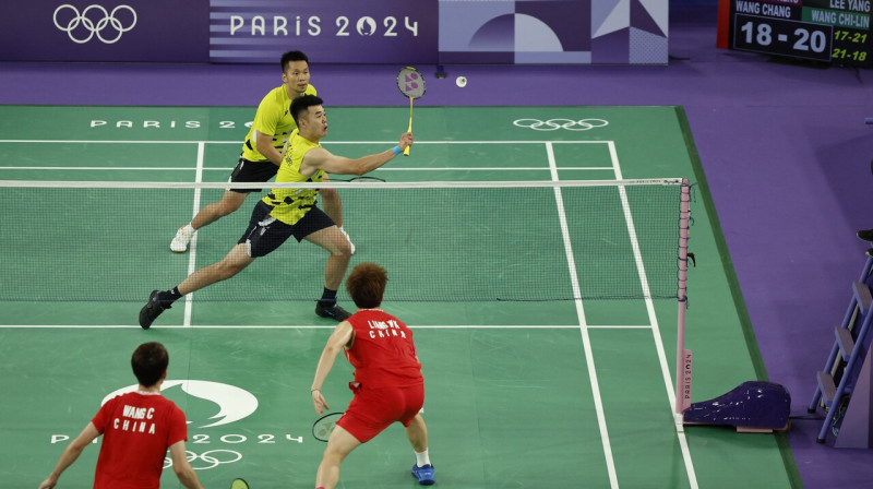 Taivānas badmintonisti Jans Lī un Čīlins Vons uzbrukumā pret ķīniešiem Parīzes olimpisko spēļu finālā. 
Foto: Hamad I Mohammed/Reuters/Scanpix